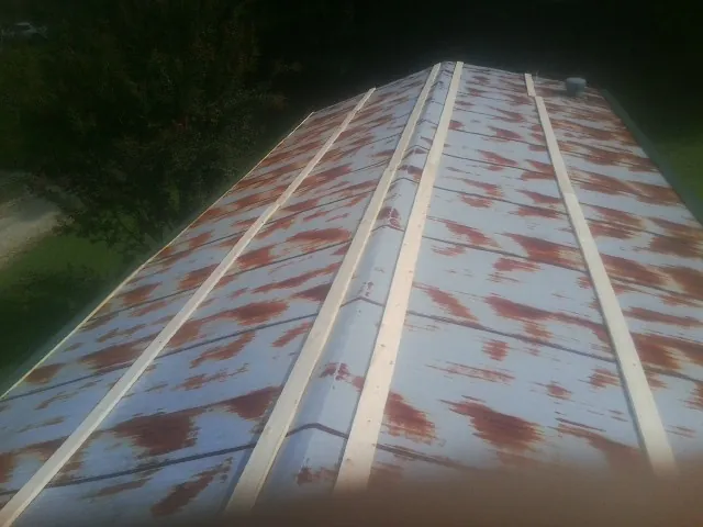 Rusted metal roof panels with new wood purlins before replacement — Storm Damage Roof Repair in East Meadow by Roofing Brothers