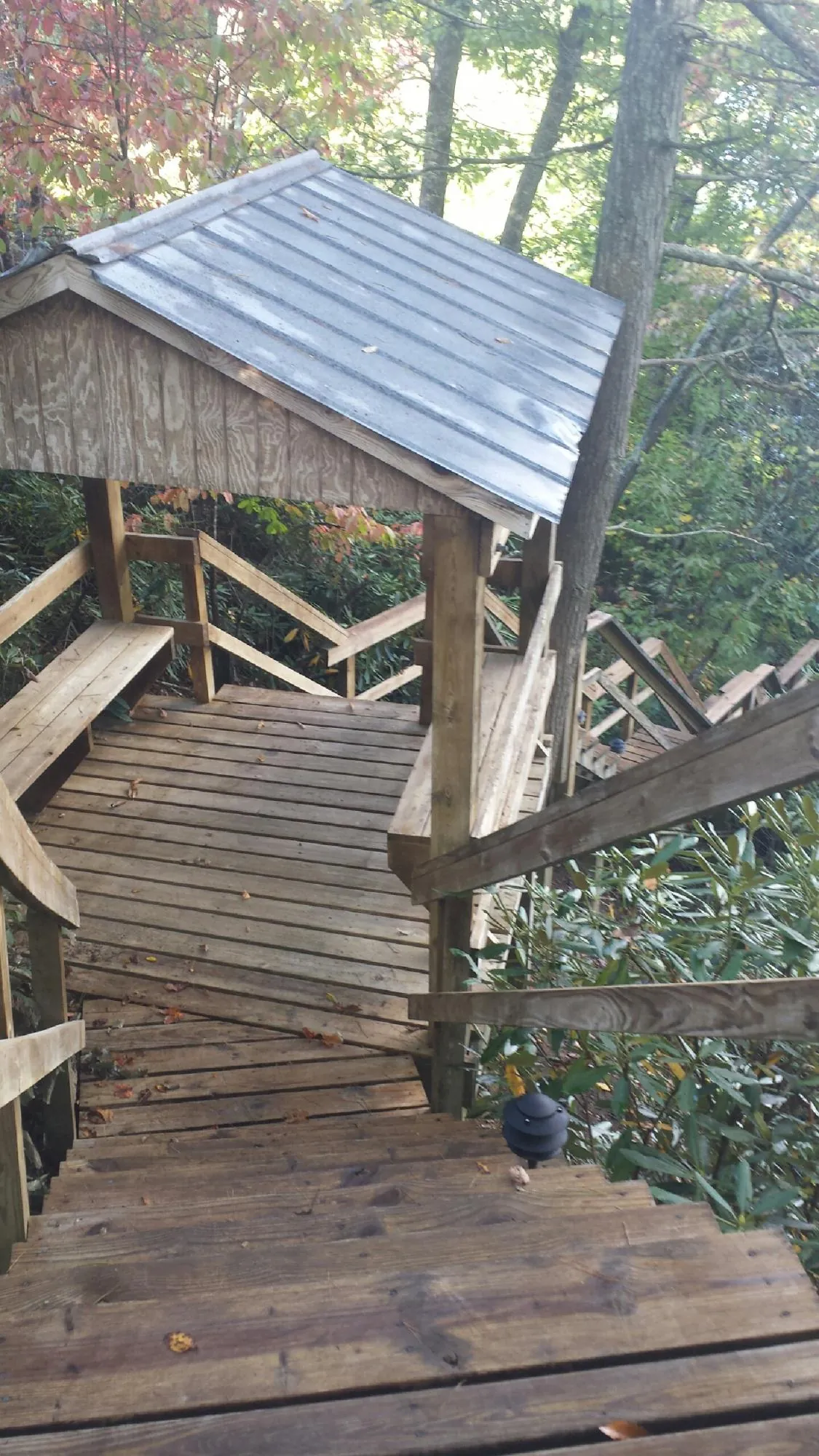 Metal roofed shelter over wooden steps on a wooded walkway — Skylight Repair & Installation work by our crew in East Meadow