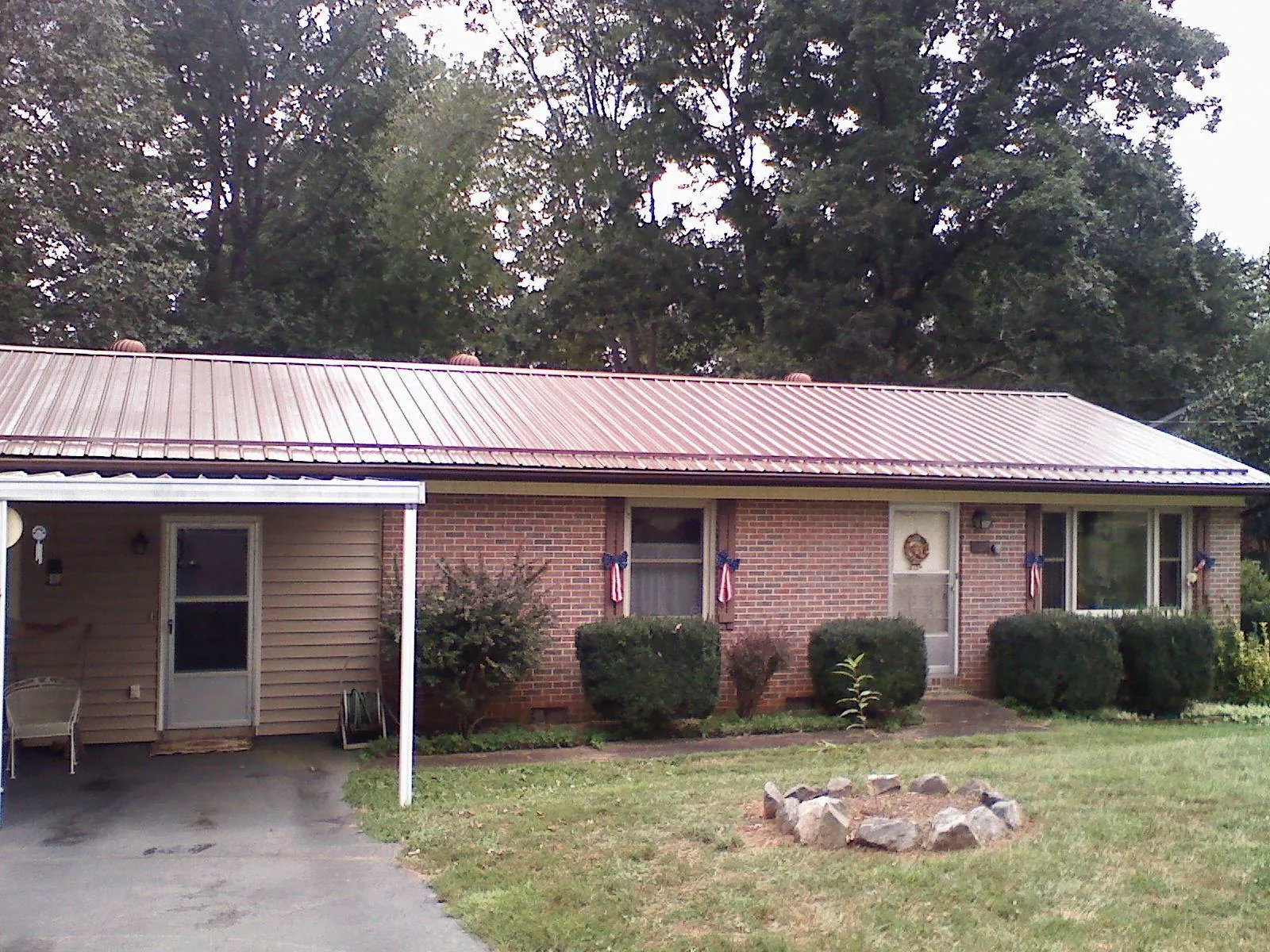Bronze metal roof and carport on a brick ranch home — Roof Repair work by our crew in East Meadow